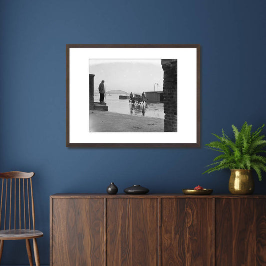 Zwart-witfoto uit 1952 van de ondergelopen Waalkade in Nijmegen door hoogwater op de Waal. – donkerbruine wissellijst in woonkamer