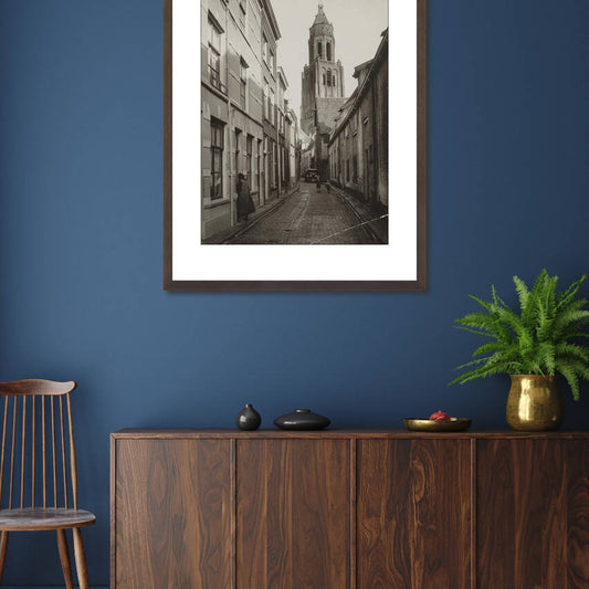Zwart-witfoto van de Trompetsteeg in Arnhem met zicht op de toren van de Grote Kerk. – donkerbruine wissellijst in woonkamer