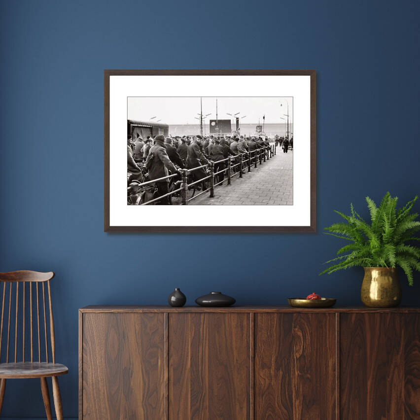 Zwart-witfoto uit 1956 van fietsers in opstelling voor de veerpont op de Buiksloterweg in Amsterdam. – donkerbruine wissellijst in woonkamer