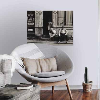 Zwart-witfoto uit omstreeks 1956 van twee meisjes en een man voor hun woonhuis in de Anjelierstraat in de Jordaan in Amsterdam. – canvas zonder lijst in leeshoek