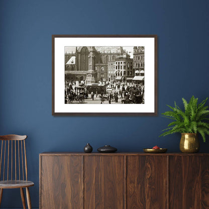 Zwart-witfoto uit 1895 van het Damplein in Amsterdam vol met mensen. – donkerbruine wissellijst in woonkamer