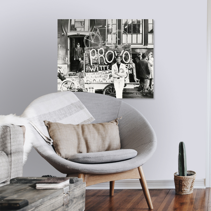 Zwart-witfoto uit 1967 van Provo Bernhard de Vries met zijn Witte Fietsenplan op de Dam in Amsterdam. – canvas zonder lijst in leeshoek