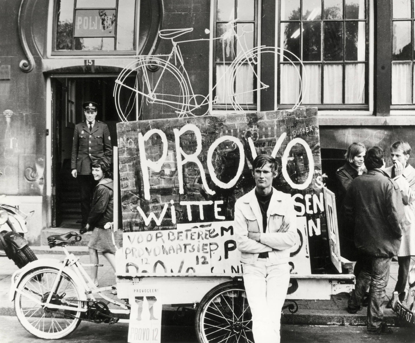 Zwart-witfoto uit 1967 van Provo Bernhard de Vries met zijn Witte Fietsenplan op de Dam in Amsterdam.