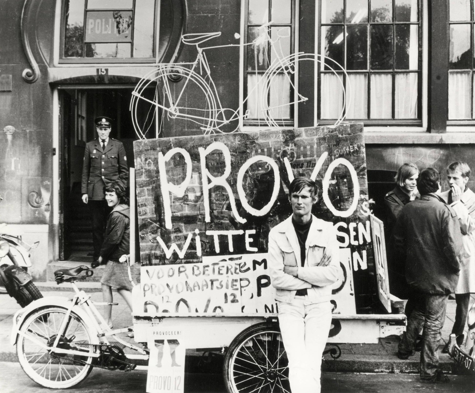 Zwart-witfoto uit 1967 van Provo Bernhard de Vries met zijn Witte Fietsenplan op de Dam in Amsterdam.