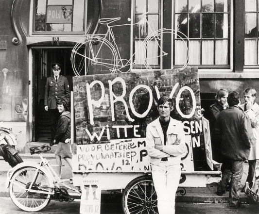 Zwart-witfoto uit 1967 van Provo Bernhard de Vries met zijn Witte Fietsenplan op de Dam in Amsterdam.