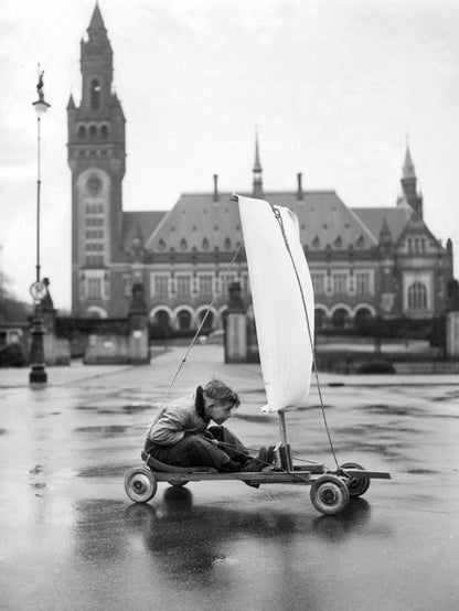 Zwart-witfoto uit 1951 van een jongen die zich vermaakt in de Haagse Nieuwstraat in Den Haag.