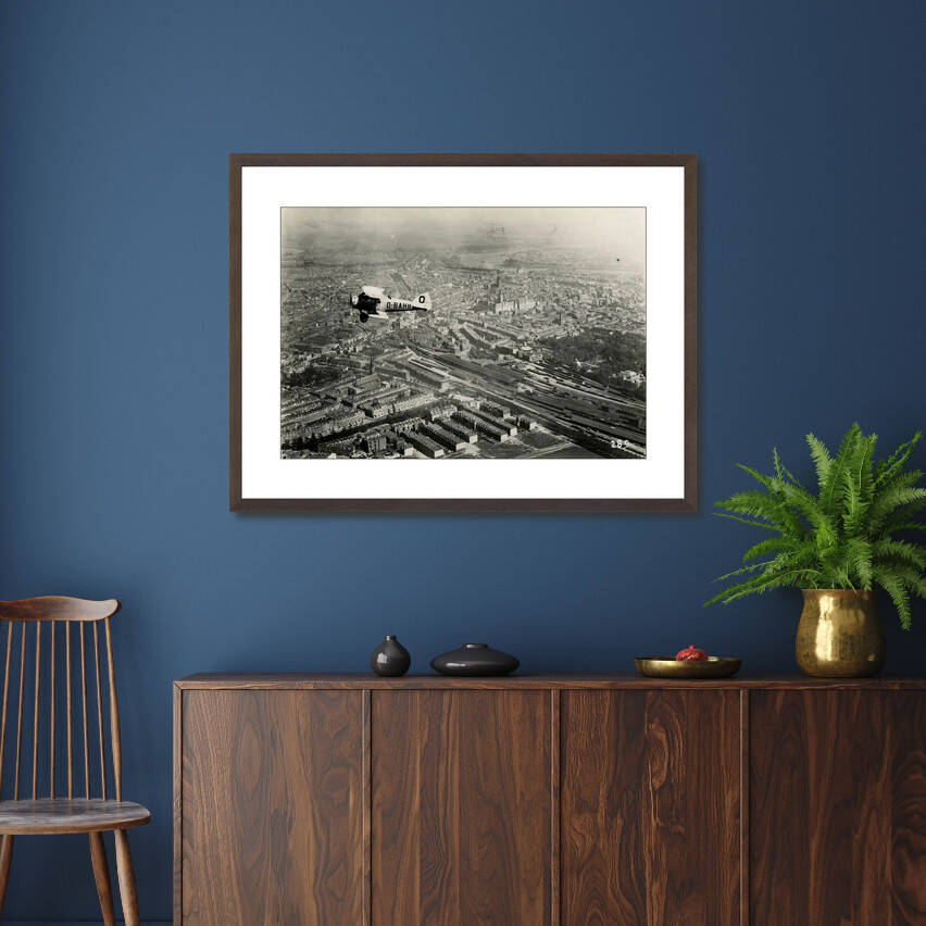 Historische foto van een vliegenier boven het centrum rond 1923 – canvas zwarte baklijst in slaapkamer
