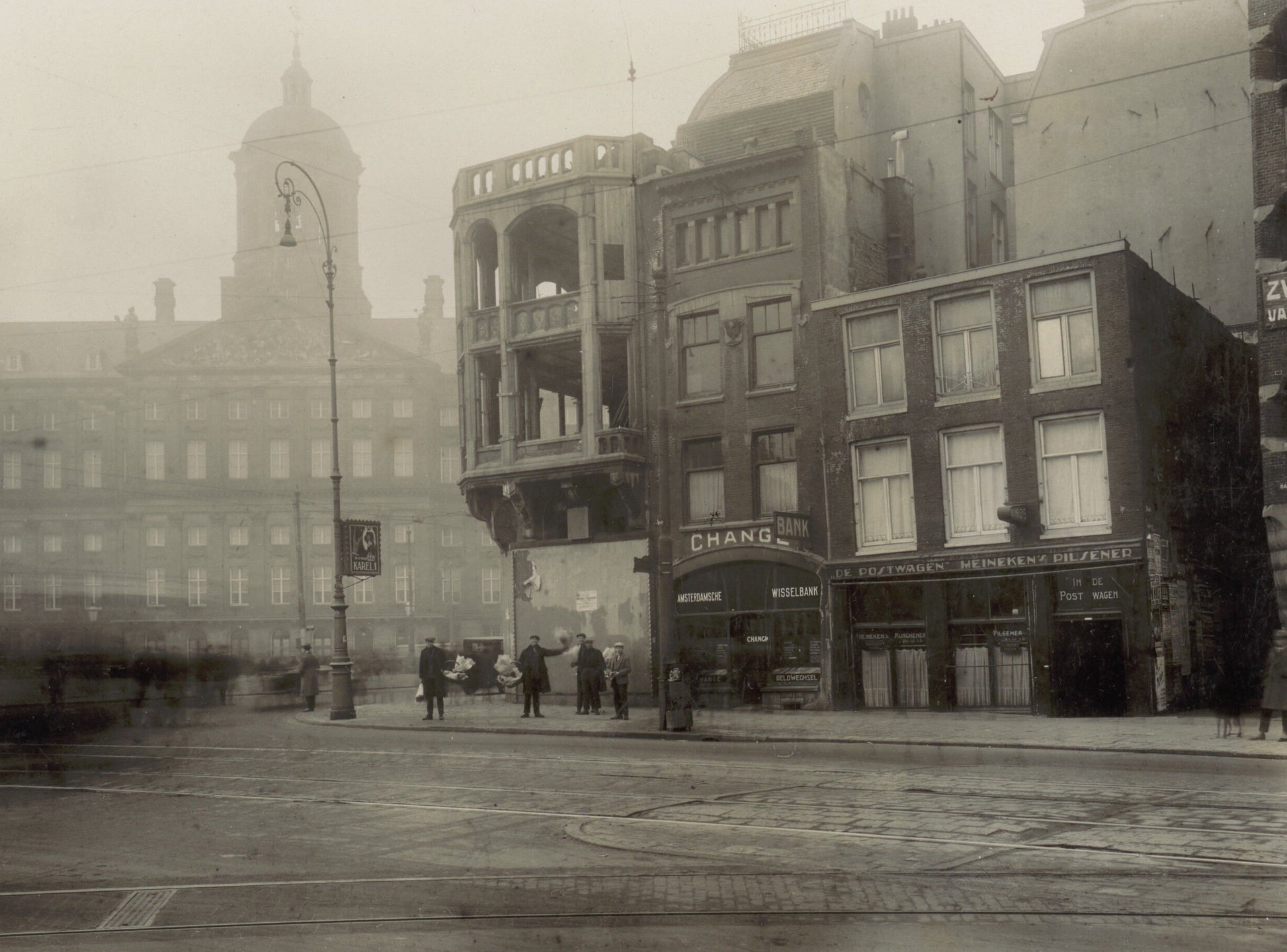Zwart-witfoto uit 1928 van het Damrak in Amsterdam, gezien naar de Dam met het Koninklijk Paleis.