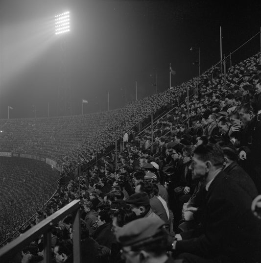 Historische foto van supporters in een nachtelijke Kuip in Rotterdam rond 1963