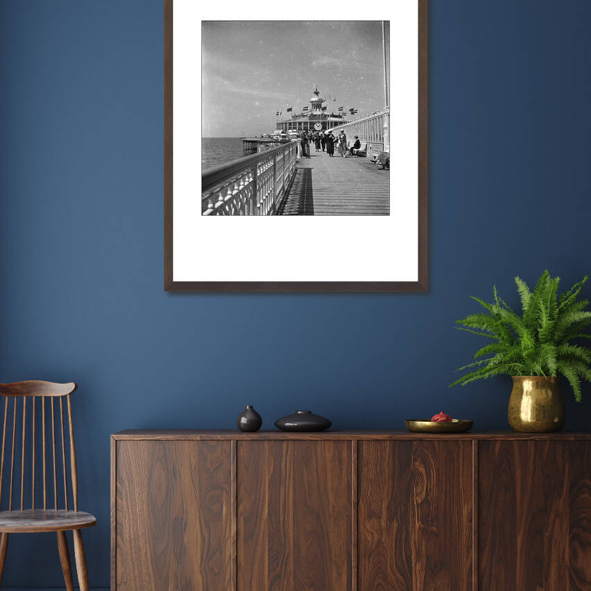Zwart-witfoto uit omstreeks 1935 van het Wandelhoofd Wilhelmina (de oude Pier) op Scheveningen. – donkerbruine wissellijst in woonkamer