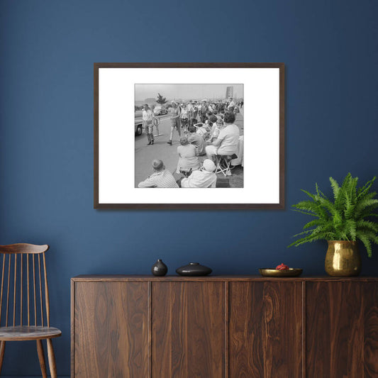 Zwart-witfoto uit 1961 van toeschouwers en lopers tijdens de Vierdaagse in Nijmegen met de Waalbrug op de achtergrond. – donkerbruine wissellijst in woonkamer