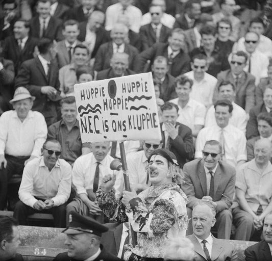 Zwart-witfoto uit 1964 van een verklede NEC-supporter in het Goffertstadion te Nijmegen.