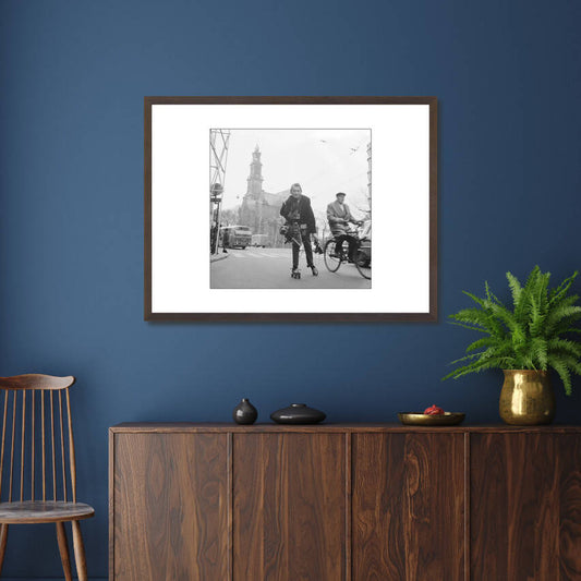 Zwart-witfoto uit 1966 van Anefo-fotograaf Jack de Nijs op rolschaatsen in Amsterdam. – donkerbruine wissellijst in woonkamer