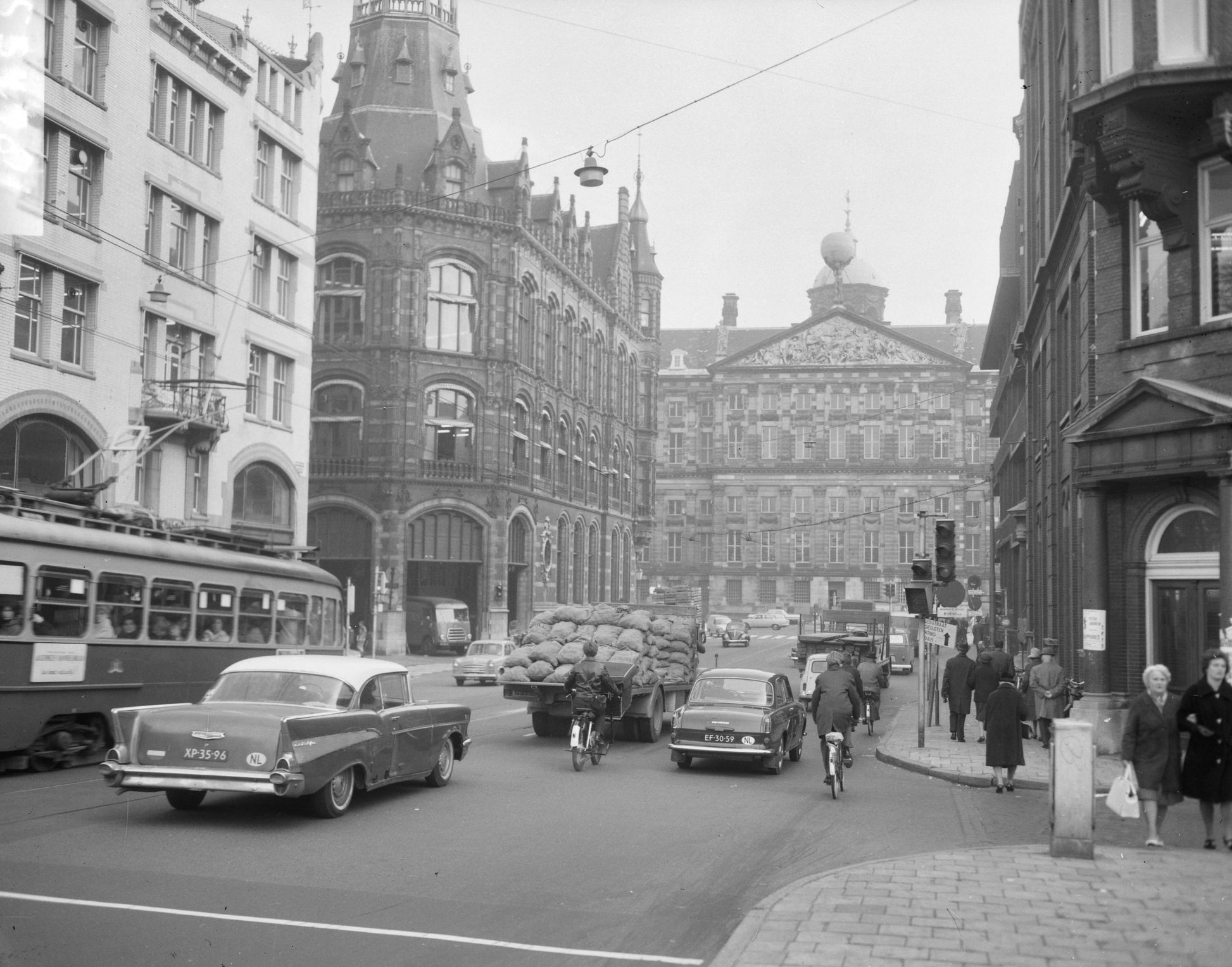 Zwart-witfoto uit 1965 van het Paleis op de Dam in Amsterdam, gezien vanuit de Raadhuisstraat.