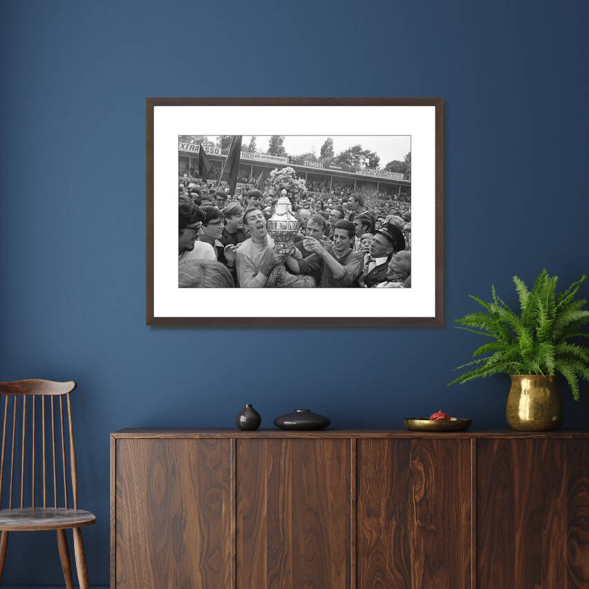 Zwart-witfoto uit 1968 van spelers van ADO Den Haag met de KNVB-beker na de finale tegen Ajax. – donkerbruine wissellijst in woonkamer