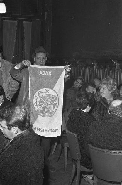 Zwart-witfoto uit 1969 van Ajax-supporters die terugkeren op Amsterdam Centraal na een Europese wedstrijd in Parijs.