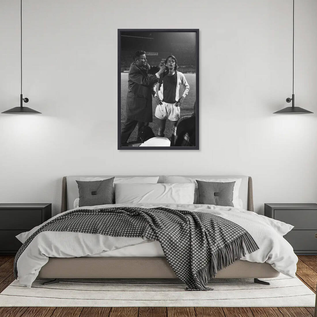 Zwart-witfoto uit 1971 van Johan Cruijff die wordt verzorgd door Ajax-clubarts Rolink in Amsterdam. – canvas zwarte baklijst in slaapkamer