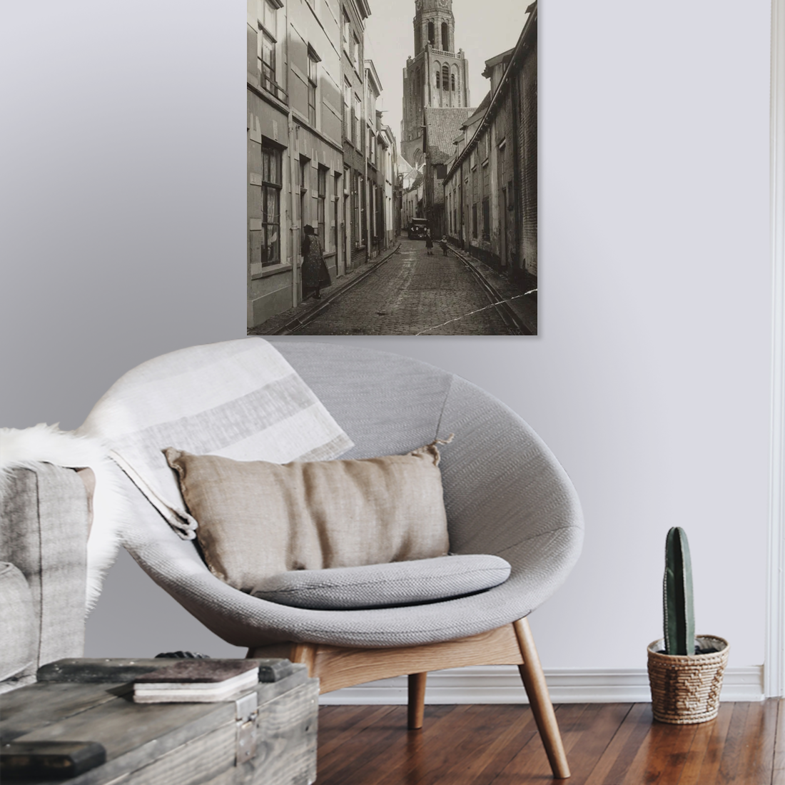 Zwart-witfoto van de Trompetsteeg in Arnhem met zicht op de toren van de Grote Kerk. – canvas zonder lijst in leeshoek