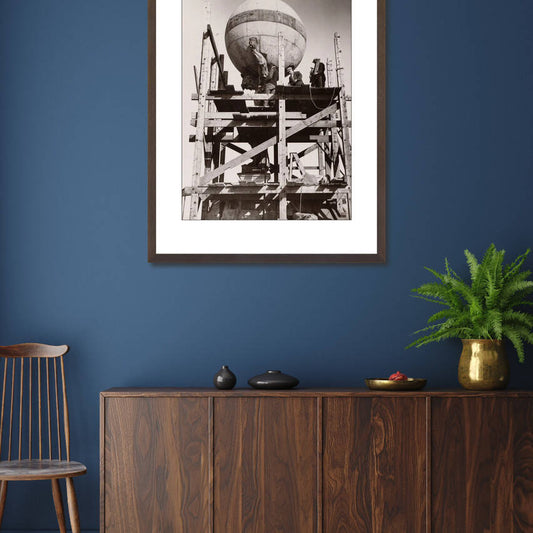 Zwart-witfoto uit 1932 van herstelwerkzaamheden aan het Koninklijk Paleis in Amsterdam. – donkerbruine wissellijst in woonkamer