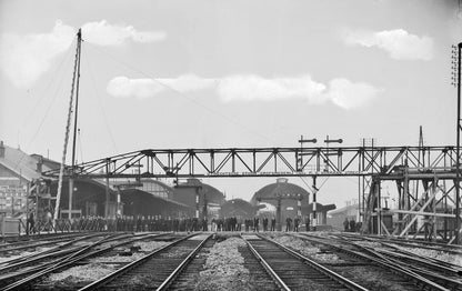 Zwart-witfoto uit 1904 van het plaatsen van een ijzeren hulpvoetbrug over de Oudegracht in Utrecht.