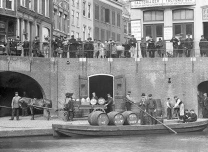 Zwart-witfoto uit 1906 van het overladen van wijnvaten aan de Oudegracht in Utrecht.