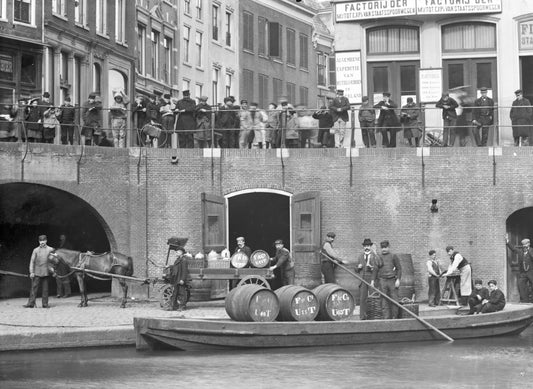 Zwart-witfoto uit 1906 van het overladen van wijnvaten aan de Oudegracht in Utrecht.