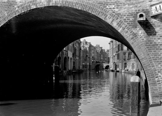 Zwart-witfoto uit 1933 van een doorkijk op de Oudegracht in Utrecht vanaf de werf.