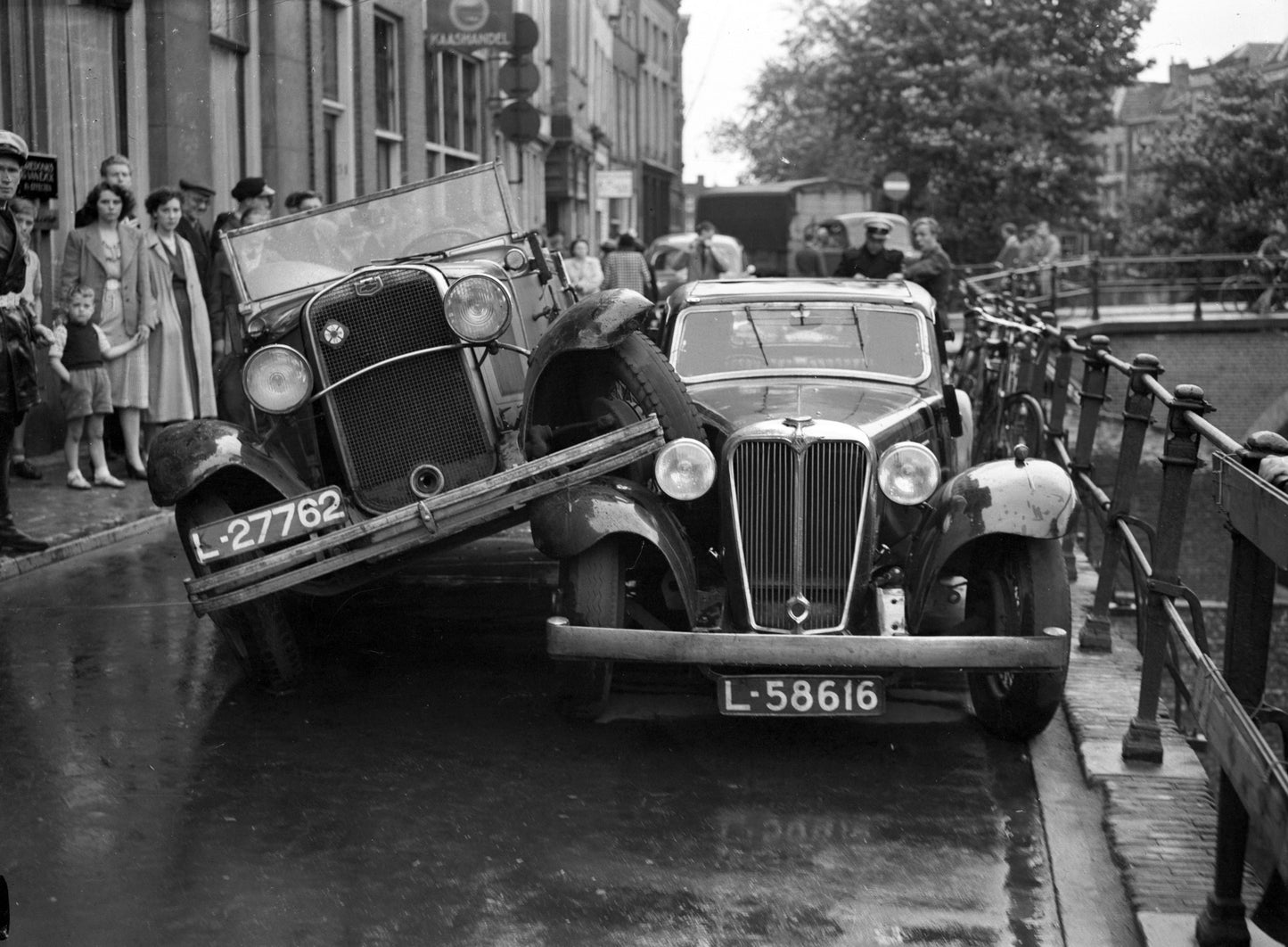 Zwart-witfoto uit 1951 van een aanrijding tussen twee auto's op de Oudegracht in Utrecht.